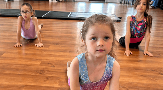Spark dancers stretching on the studio floor during class